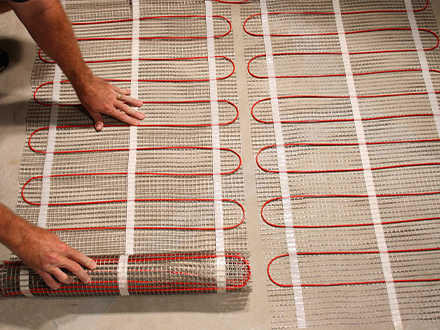 ComfortTile radiant floor heating system being installed.
